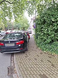 Autos parken auf dem Gehweg.