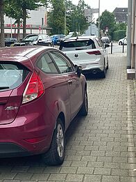 Autos parken teilweise auf dem Gehweg.