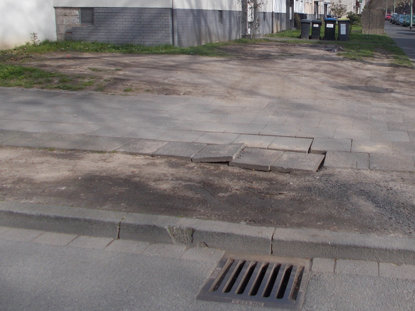 Überfahrener Gehweg und Grünstreifen ist dadurch beschädigt.